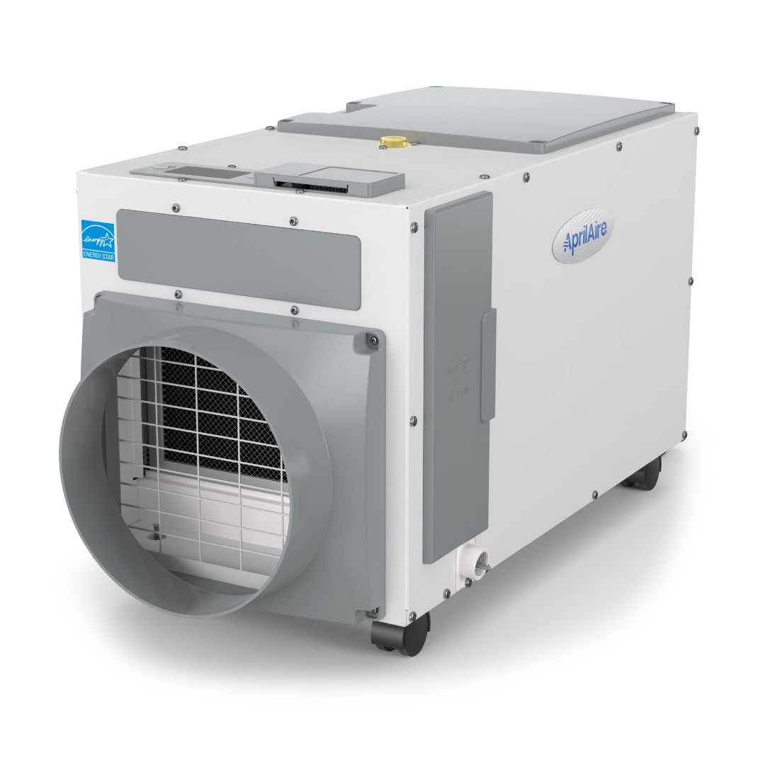 White AprilAire E100C dehumidifier cabinet with a circular duct opening, side access panel, front grille, drain connection and four visible caster wheels.