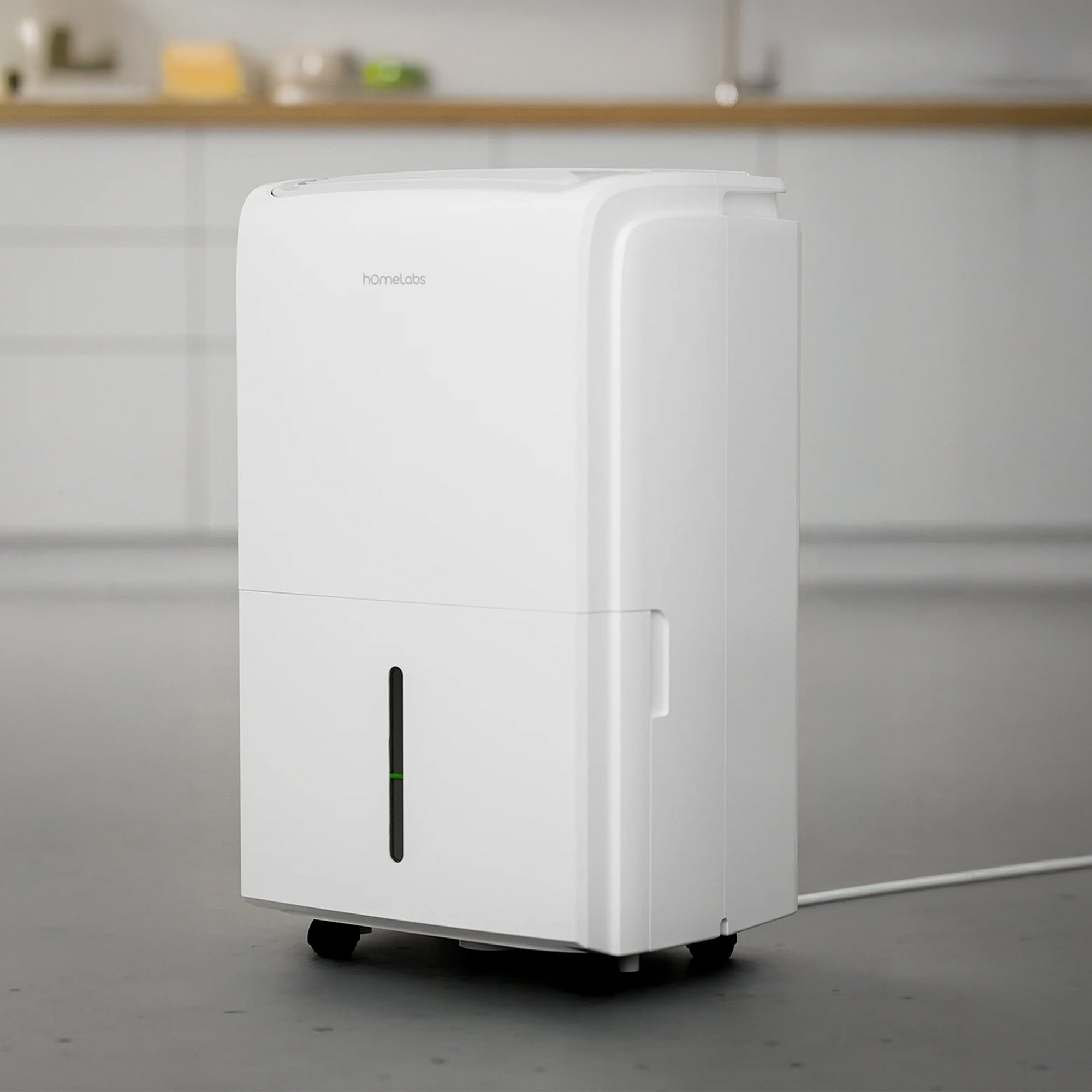 White hOmeLabs 40-pint dehumidifier in a room setting, with front tank-level window, top outlet area and casters.